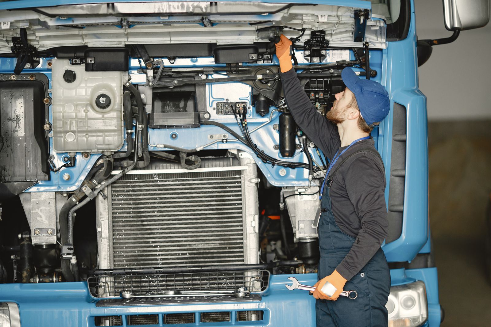 Mechanic working on the engine bay of a heavy-duty truck