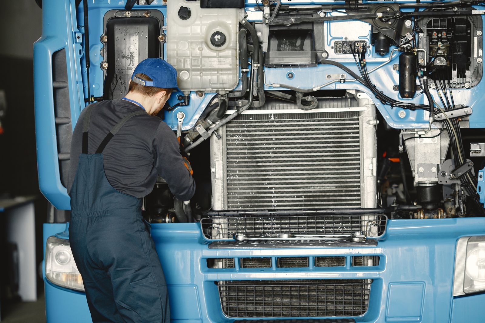 Mechanic performing preventive maintenance on a truck's cooling system